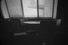 Svartvit stillbild från videoverket Ekon från den andra stranden. Tomt i restaurangdel på en färja. 
